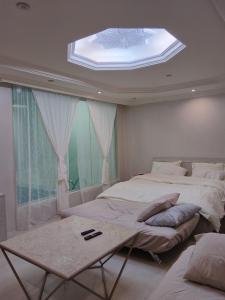 a bedroom with two beds and a window with a skylight at استراحة المهند in Al-Salam