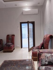 a living room with two chairs and a door at استراحة المهند in Al-Salam