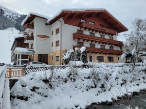ein großes Gebäude mit Schnee auf dem Boden in der Unterkunft Hotel Sommerer - inklusive JOKER CARD im Sommer in Saalbach-Hinterglemm