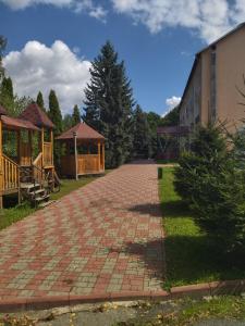 a brick driveway with a gazebo and a building at Санаторій Збруч in Satanov