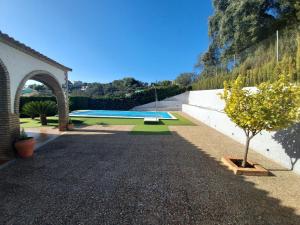 a garden with a swimming pool and a tree at La encina in Guillena
