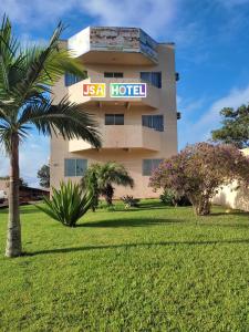 a usa hotel with a palm tree in front of it at JSA Hotel in Siqueira Campos