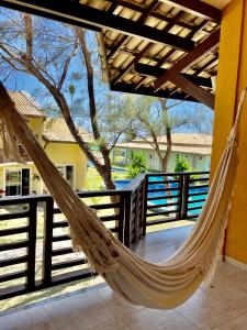 a hammock on a porch with a fence at O Paraíso é aqui: Pé na Areia em Arembepe in Camaçari