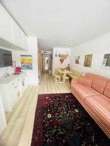 uma sala de estar com um sofá vermelho e uma cozinha em Casa degli orsi - Madonna di Campiglio - Condominio Nardis em Madonna di Campiglio