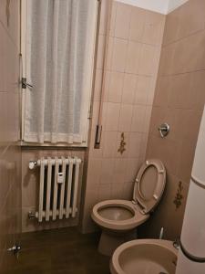 een kleine badkamer met een toilet en een radiator bij Camera Alex in Pavia