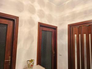 een kamer met 2 houten deuren en een spiegel bij Camera Alex in Pavia