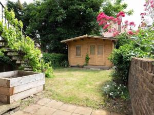 a small wooden house in a yard with flowers at Warwick Weekender in Margate