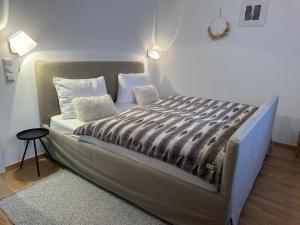 Una cama grande con almohadas y una manta. en ALPEN WOHLFÜHLQUARTIER, en Bad Bayersoien