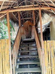 una escalera que conduce a un edificio con techo en Seasons Four Eco Friendly Treehouse, en Matara