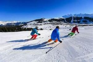a group of three people skiing down a snow covered slope at Appartement T3 in Frontenex-Villard-Rosset