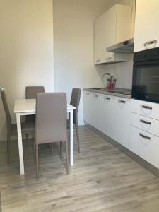 uma cozinha com uma mesa e cadeiras numa cozinha em Appartamento a 200 mt dal mare em Lido di Jesolo