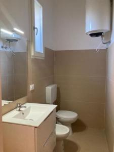 uma casa de banho com um lavatório, um WC e um espelho. em Appartamento a 200 mt dal mare em Lido di Jesolo