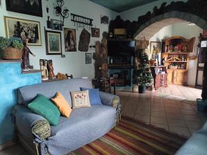 een woonkamer met een bank en een tv bij Casa Sa Hosta in Gavoi