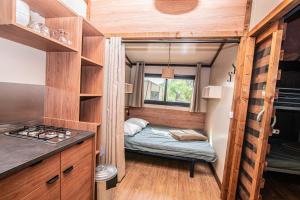 ein winziges Haus mit einem Bett in der Mitte in der Unterkunft Camping Onlycamp de Wasselonne in Wasselonne