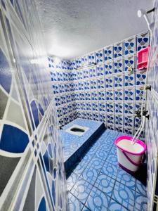 a blue and white bathroom with a pink toilet at Lumina Home Stay in Puducherry