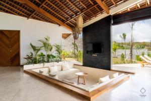 a living room with a couch and a table at Sundance Residence Nusa Penida - 2 Bedroom with Private Pool Villa in Tanglad