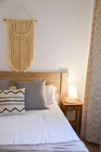 a bedroom with a white bed with a chandelier above it at La Neu Studio neuf pour 4 pax en centre ville in Pas de la Casa
