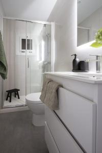 a white bathroom with a toilet and a shower at Feel Welcome Barcelona # SPLAU in Cornellà de Llobregat