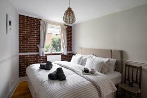 2 camas en un dormitorio con una pared de ladrillo en Pound Street en Exmouth