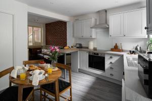 uma cozinha com armários brancos e uma mesa com comida em Pound Street em Exmouth