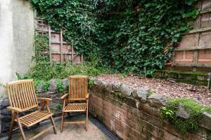 two chairs sitting next to a brick wall at Pound Street in Exmouth