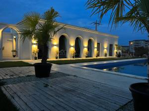 un bâtiment avec un palmier en face d'une piscine dans l'établissement Villa Gyos, à Costinesti