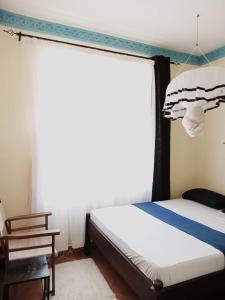 - une chambre avec un lit et une fenêtre dans l'établissement Marieella homes, à Ukunda