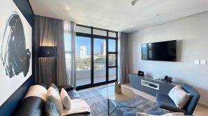 uma sala de estar com um sofá e uma televisão em Pearls Apartments - Sea Facing em Durban