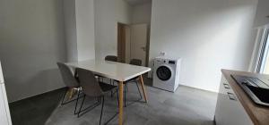 a room with a table and chairs and a washing machine at Timeless: 4 Zimmer Apartment OG Ludwigsburg in Ludwigsburg