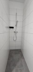 a shower in a white tiled bathroom at Timeless: 4 Zimmer Apartment OG Ludwigsburg in Ludwigsburg