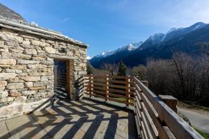 PiuroBel Sass的一座有木栅栏和山脉的石头建筑