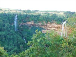a large waterfall in the middle of a forest at Fountainhill Estate Accommodation in Wartburg