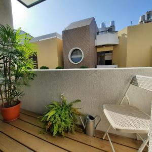 uma varanda com uma cadeira e plantas num edifício em 珍遇珍寓電梯民宿 June June House em Tainan