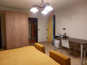 een kamer met een bed, een tafel en een keuken bij Camera dei Tigli in Cherasco