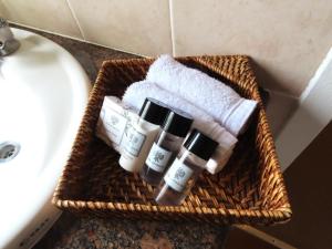 a basket with three bottles of essential oils next to a sink at Fountainhill Estate Accommodation in Wartburg