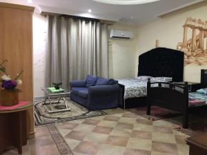 a living room with a couch and a bed at Backpackers Place - Central Bus Terminal in Abu Dhabi