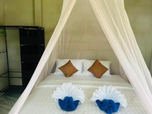 a white bed with two blue pillows on it at Happy Home Kohjum in Ko Jum +45 photos