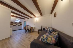a living room with a couch and a kitchen at Camere de închiriat Larisa in Moieciu de Sus