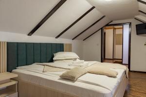 a bedroom with a large bed with a green wall at Camere de închiriat Larisa in Moieciu de Sus