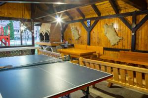 a dining room with a table and benches at Camere de închiriat Larisa in Moieciu de Sus