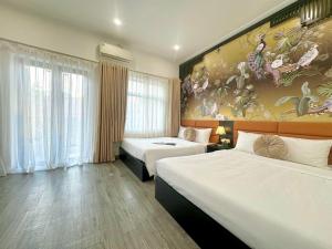 a hotel room with two beds and a painting on the wall at Hanoi Elpis Hotel in Hanoi