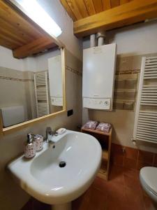 y baño con lavabo blanco y aseo. en Relais du Bourg, en Roisan