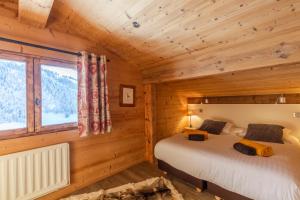 1 dormitorio con 1 cama en una cabaña de madera en Chalet Coelacanthe, en La Clusaz