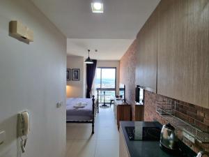 een kamer met een slaapkamer, een bed en een keuken bij unixx condo pattaya near walking street in Pattaya South