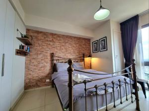 a bedroom with a bed and a brick wall at unixx condo pattaya near walking street in Pattaya South