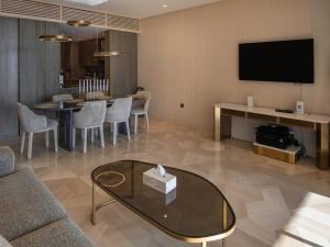 a living room with a couch and a table with a tv at FIVE Palm Residences in Dubai