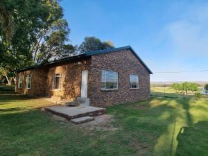 a brick house in the middle of a field at Sunrise Serenity Guest House in Lydenburg