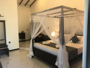 una camera con letto a baldacchino e zanzariere di skyresort a Tangalle