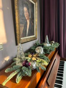 une peinture d'une femme sur un piano avec des décorations de Noël dans l'établissement La Vigie, Spa, à Spa