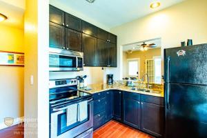 a kitchen with black cabinets and a black refrigerator at Easy A - Flat in heart of N Hyde Park U of Tampa in Tampa